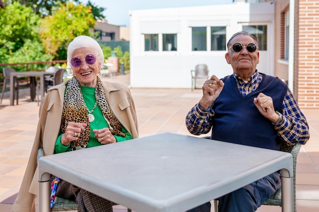 Ouderen Bliss Vreugdevol dansende duo Zonnige tuin Stijlvolle schaduwen in een verzorgingshuis