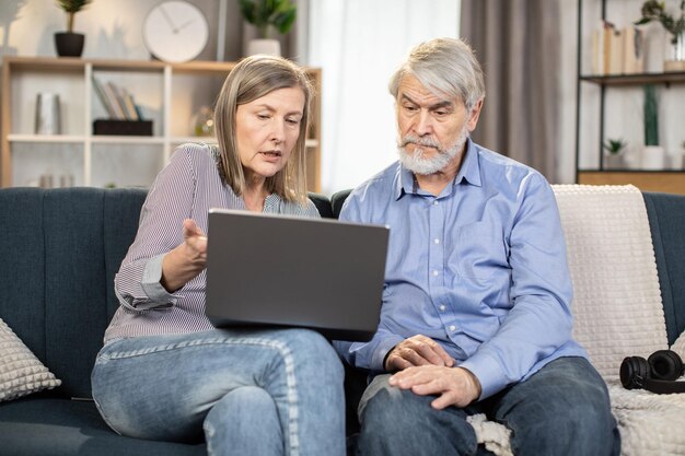 Ouderen met laptop genieten van vrije tijd thuis