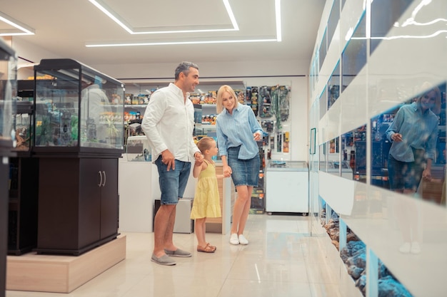 Ouders die hun kleine meisjesvissen laten zien tijdens een bezoek aan het aquarium