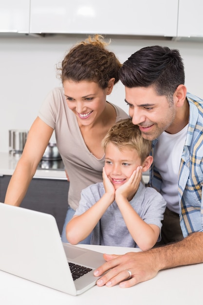 Ouders die laptop met hun zoon gebruiken