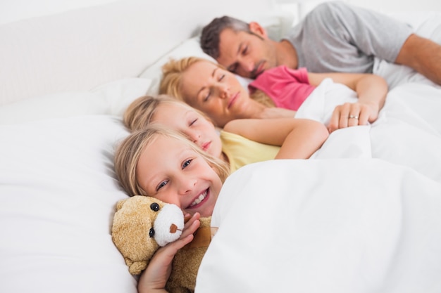 Foto ouders die met hun dochters in bed slapen