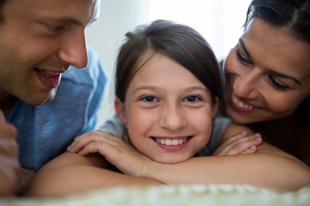 Ouders en dochter liggend in de slaapkamer