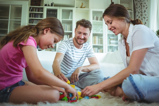 Ouders en dochter spelen met bouwstenen