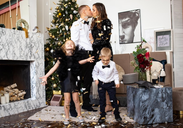 Ouders en hun kinderen, dochter en zoon die thuis op Kerstmis wachten Familiekerstmis thuis