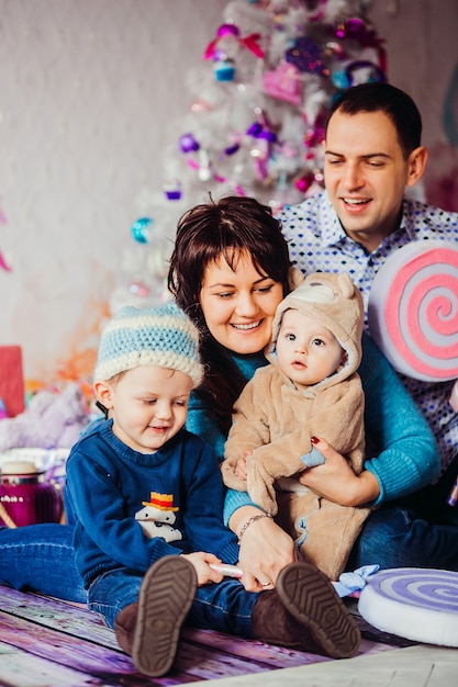 Ouders en hun kleine zonen spelen met grote speelgoedsnoepjes