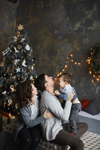 ouders en hun zoontje hebben plezier met Kerstmis