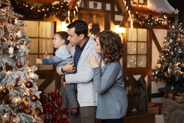 ouders en hun zoontje hebben plezier met Kerstmis