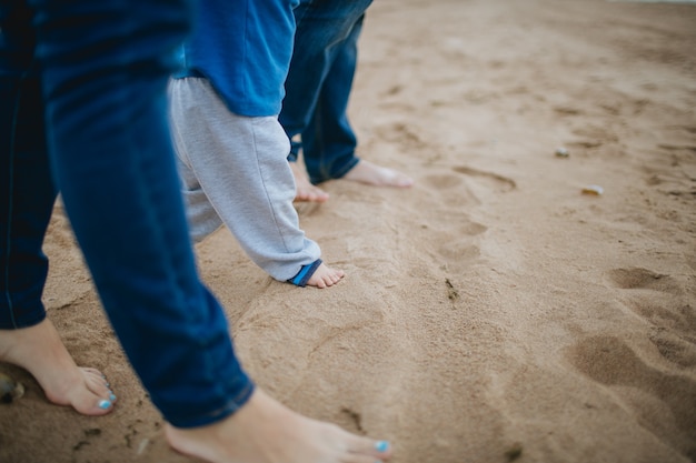 Ouders en kind stappen in het zand