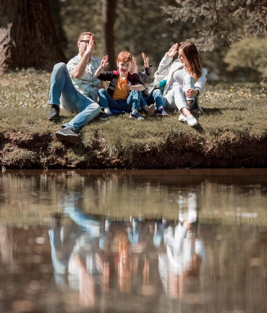 Ouders en kinderen geven elkaar een high five tijdens een wandeling in het Parkhappy familieconcept