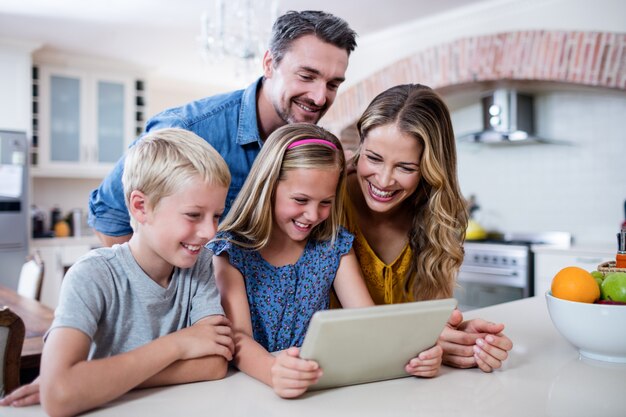 Ouders en kinderen met behulp van digitale tablet in de keuken