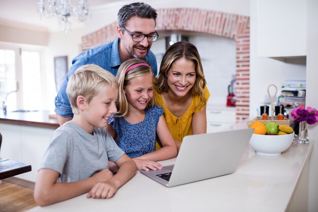 Foto ouders en kinderen met behulp van laptop in de keuken