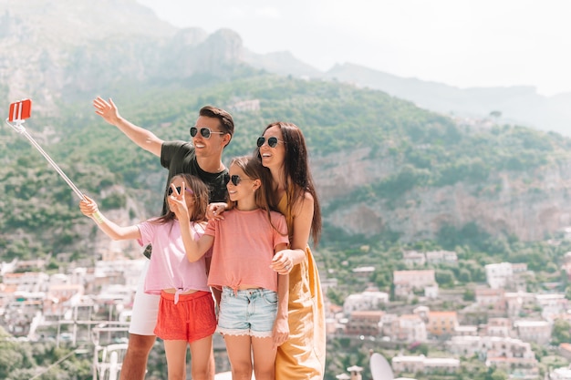 Ouders en kinderen nemen selfie foto achtergrond Positano stad in Itali aan de kust van Amalfi