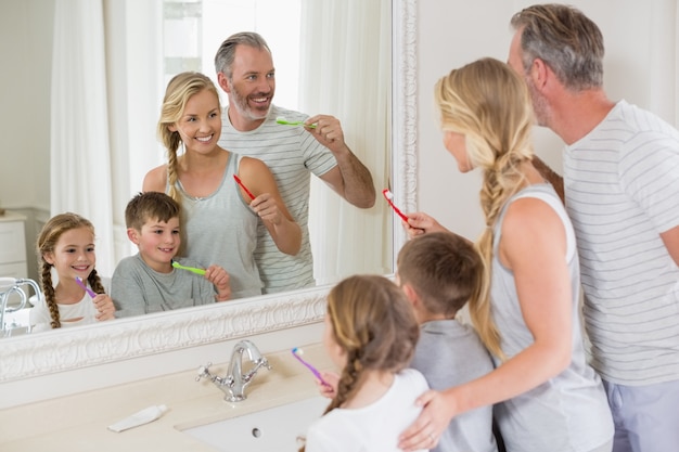 Ouders en kinderen tanden poetsen in de badkamer