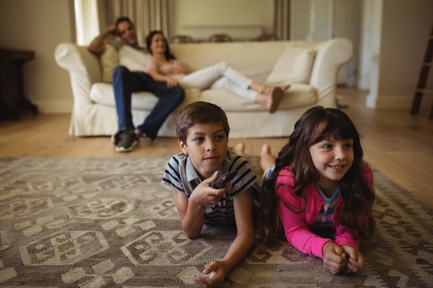 Ouders en kinderen televisie kijken in de woonkamer