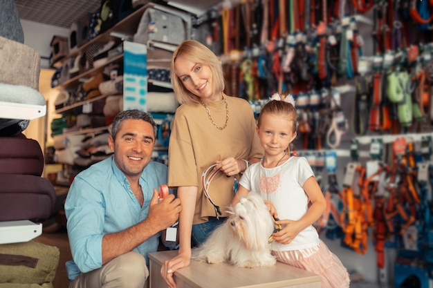 Ouders en meisje blij na het vinden van een hondenhalsband voor hun hond