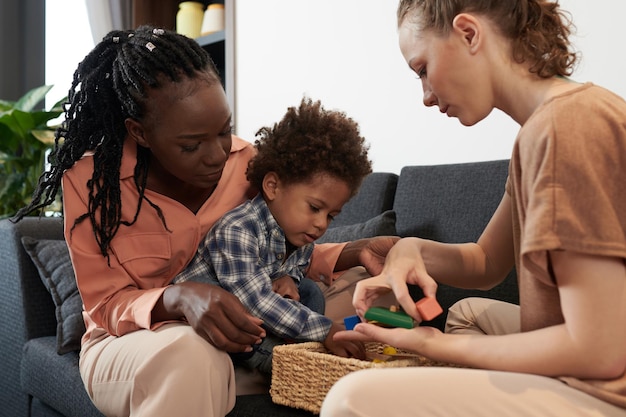 Ouders en zoon spelen met speelgoedblokken