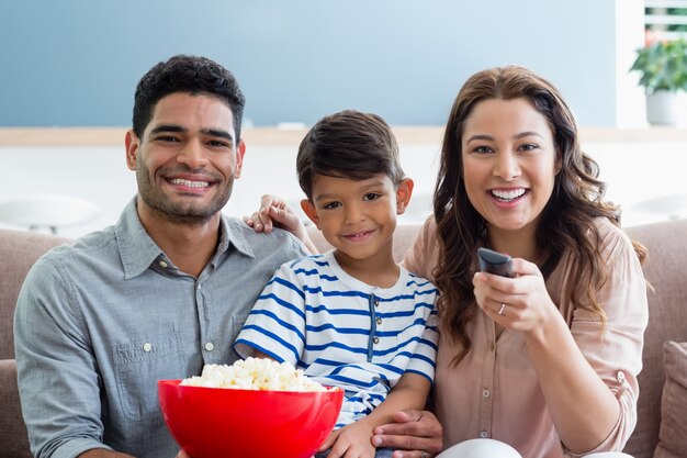 Ouders en zoon televisiekijken in de woonkamer