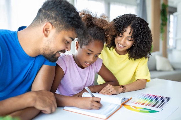 Ouders helpen kind thuis met haar huiswerk Vader en moeder helpen dochter thuis studeren