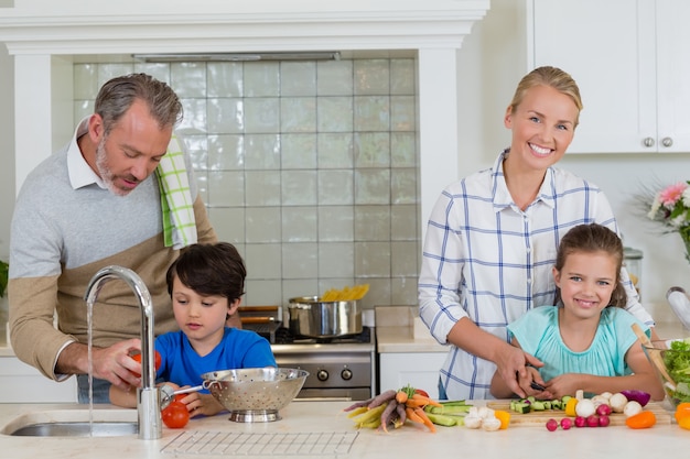 Ouders helpen kinderen om de groenten in de keuken te hakken en schoon te maken