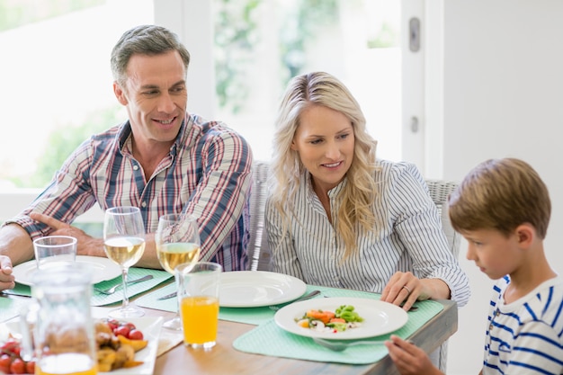 Ouders interactie met zoon op eettafel