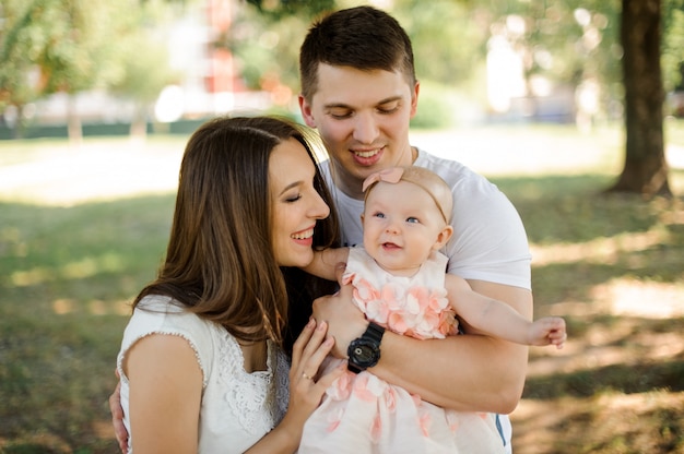 Ouders kijken op hun kleine schattige dochter in het park