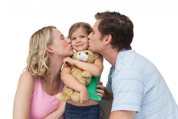 Ouders kussen hun kleine meisje op haar wangen