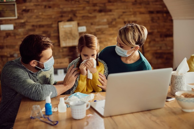 Ouders met gezichtsmaskers die thuis voor hun zieke dochter zorgen