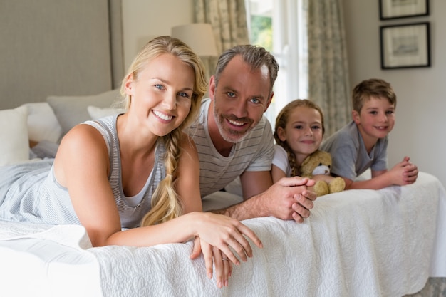 Ouders met hun kinderen liggend op bed in de slaapkamer