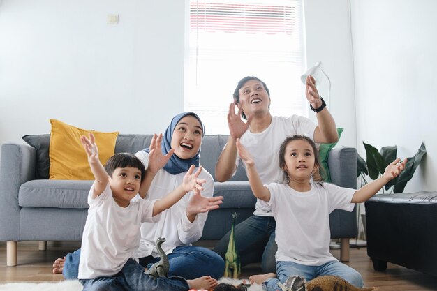 Foto ouders met twee kinderen die samen speelgoed spelen in de woonkamer gelukkige gezinsbonding thuis