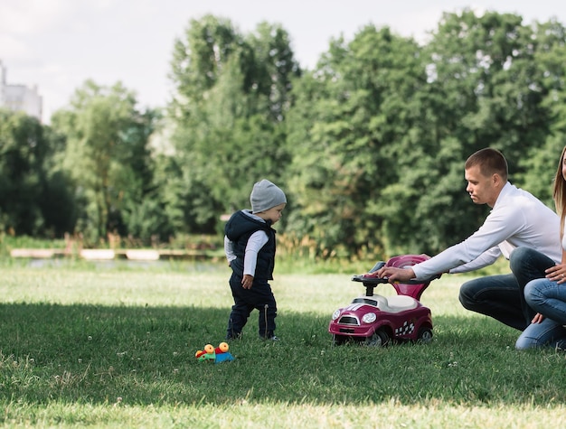 Ouders spelen met hun zoontje op het grasveld in het Park.