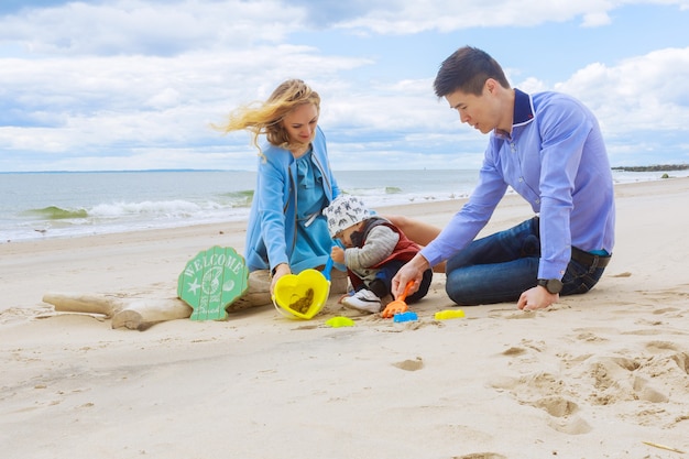 Ouders spelen met zijn zoon op het strand