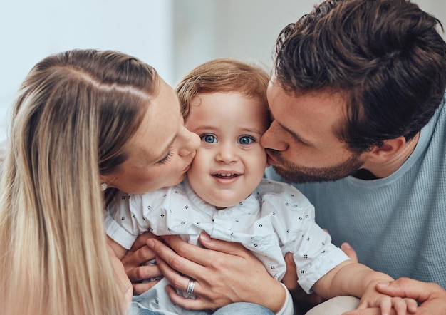 Ouders thuis en baby gezicht kus portret van een moeder vader en kind in een huis met liefde Ouderzorg ontspannen en gelukkig gezin samen met moeder vader en kind kalm met een glimlach in een huis hechting