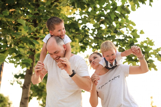 ouders vermaken hun kinderen en berijden ze op hun schouders