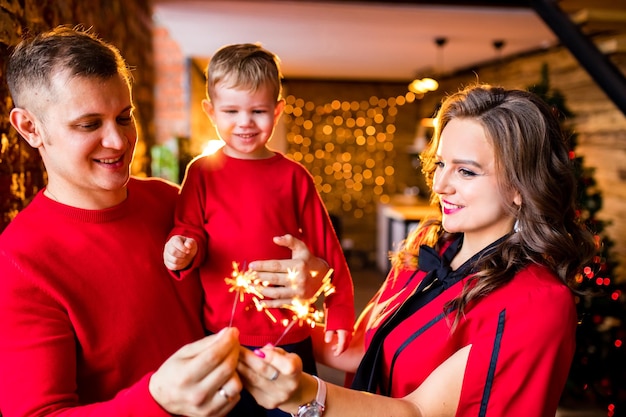 Ouders vieren oudejaarsavond thuis met kind in woonkamer