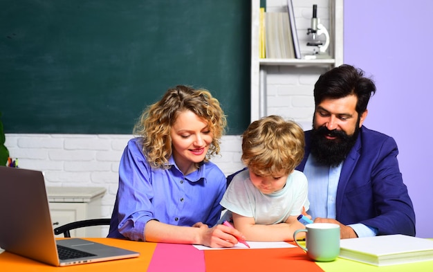 Ouderschap gelukkige familie schattige leerling en zijn ouders die scholing maken, mama en papa helpen kindjongen