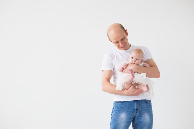 Ouderschap, gezin en vaderschap concept. Kale vader knuffelen zijn baby dochtertje