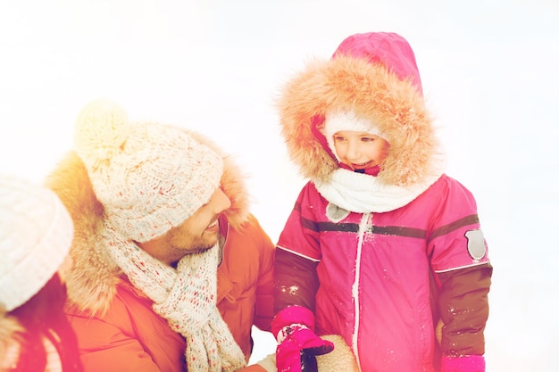 Ouderschap, mode, seizoen en mensenconcept - gelukkige familie met kind in de winterkleren in openlucht