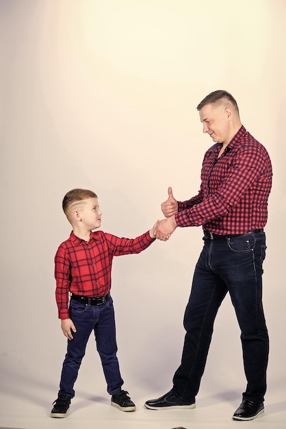 Ouderschapsconcept Vaderdag Vader voorbeeld van nobele mens Coole jongens Vader zoontje rode shirts family look outfit Beste vrienden voor altijd Geluk vader zijn van jongen Vader en schattig kind