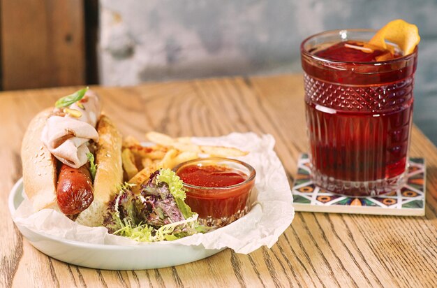 ouderwetse cocktail en bord met hotdog met worst en ham tomatensaus ketchup