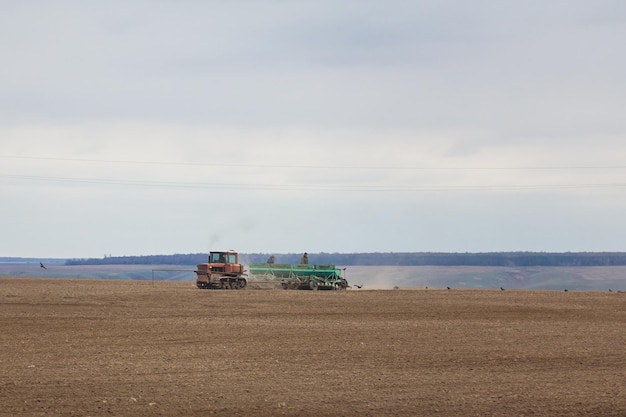 Ouderwetse tractor die gewassen zaait op het veld, telefoto