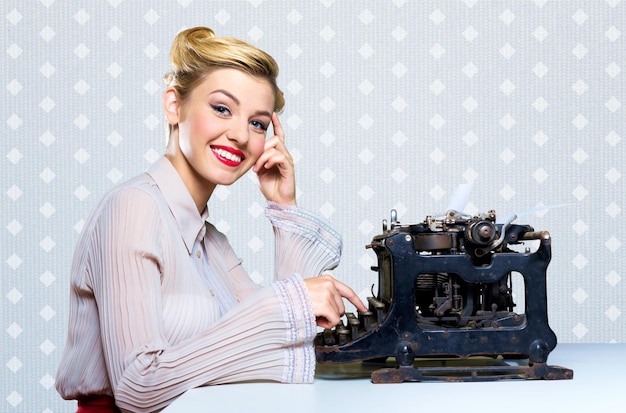 Ouderwetse vrouw die aan vintage typemachine werkt