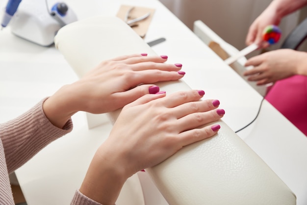 Oung woman doing manicure in salon. Beauty concept.