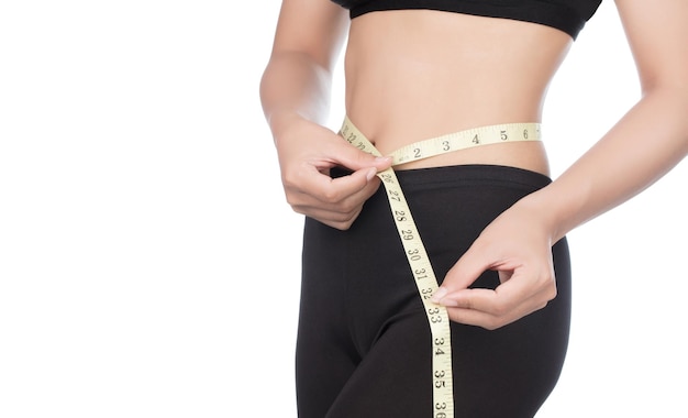 oung woman with a perfect body measures her waist with a measure band isolated on white background