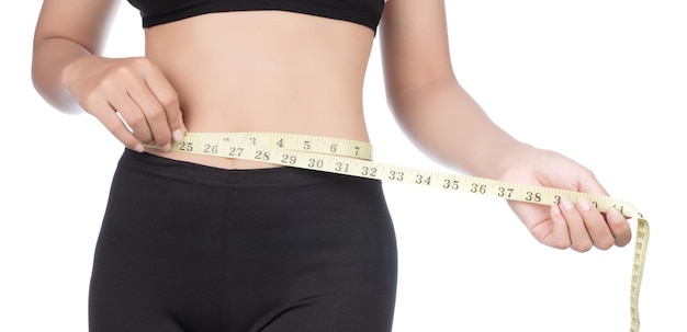 oung woman with a perfect body measures her waist with a measure band isolated on white background