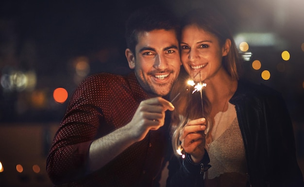 Our love will keep on sparkling Shot of a happy young couple celebrating with sparklers outside at night