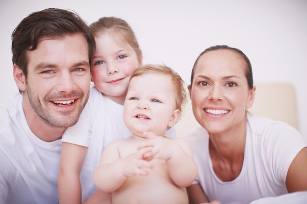 Our lovely family Cropped portrait of a loving family with two children sitting together in a bedroom