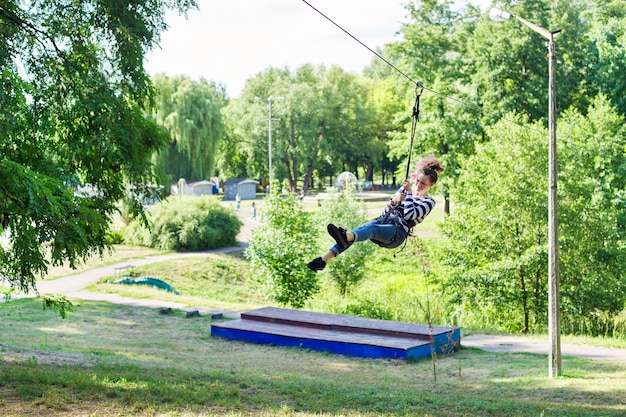 屋外のアクティブなレクリエーションと遊園地、バンジージャンプを楽しんでいるティーンエイジャーの女の子