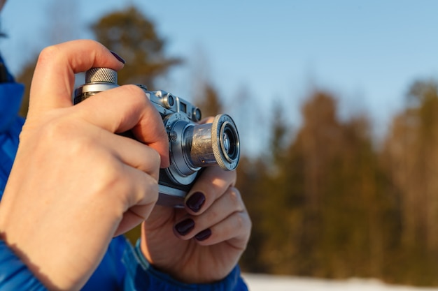 Concetto di fotografia amatoriale all'aperto, macchina fotografica d'epoca nelle mani