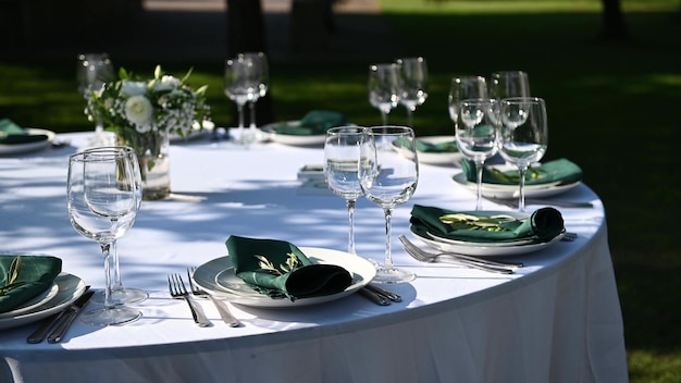 Outdoor banquet table set up served dinner tableware and silverware. Wide footage.