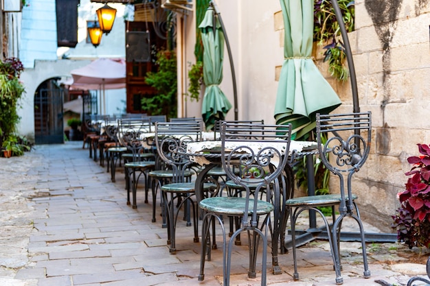 Outdoor cafe in the old town Chairs and table on empty terrace at cafe